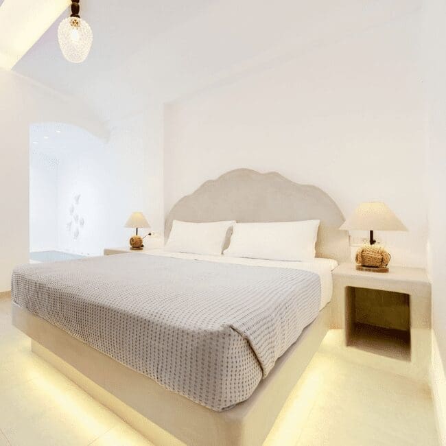 Double bed with a curved upholstered headboard in the Suite with Indoor Hot Tub