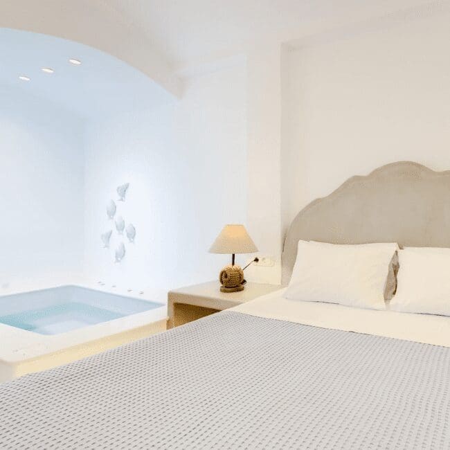 Bedroom beside an indoor mosaic hot tub in the Suite with Indoor Hot Tub