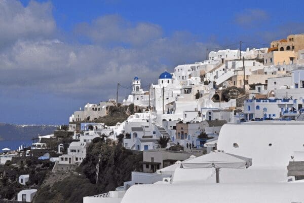 Whitewashed houses cascading down a Santorini hillside village
